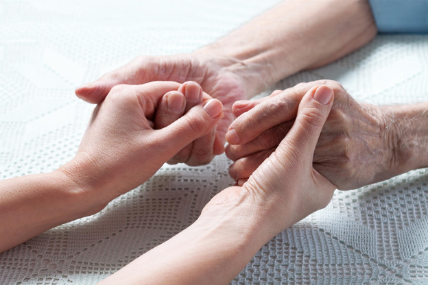 Caregiver holding hands with dementia patient
