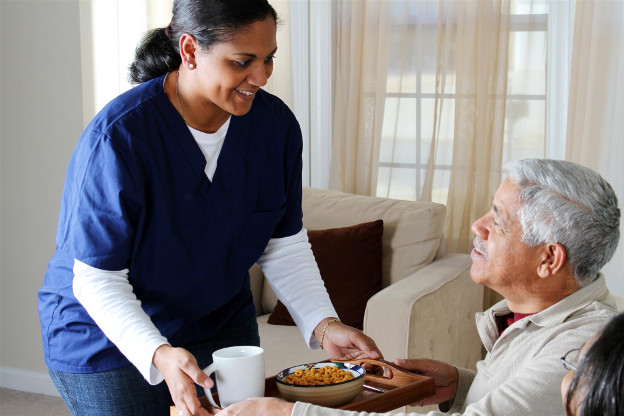 Nurse serving food to dementia patient